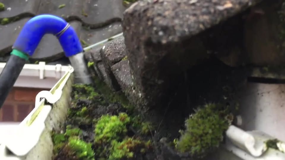 Clearing moss and debris from a gutter