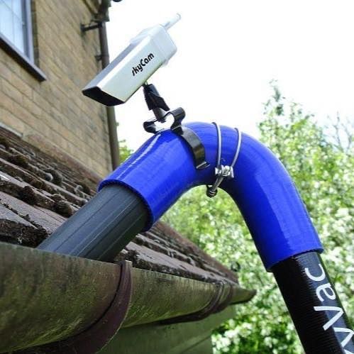Gutter vacuum clearing a gutter from the ground